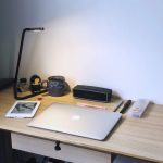 Minimalist study desk with closed laptop, tablet, lamp, pens, and coffee mug ready for a focused learning session