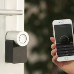 Smart lock on a door being controlled remotely via smartphone app