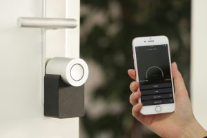 Smart lock on a door being controlled remotely via smartphone app